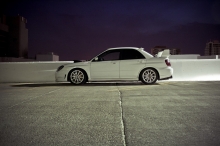 Белый Subaru Impreza на верхнем уровне парковки